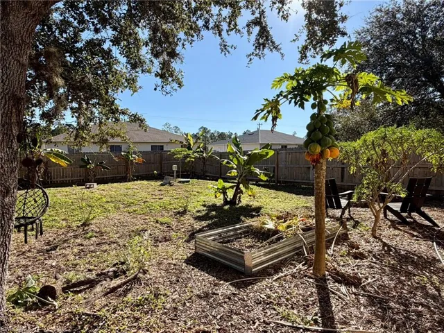 Fenced backyard featuring a garden