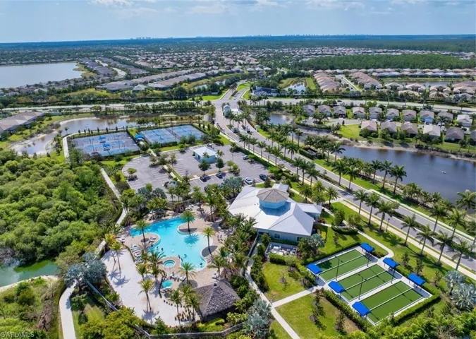 Aerial perspective of suburban area with a nearby body of water and a pool