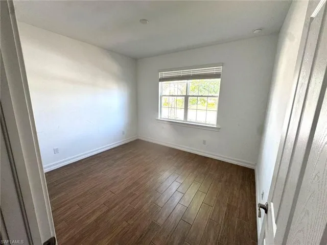 Spare room with baseboards and dark wood finished floors