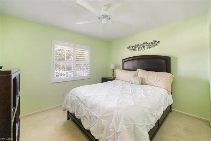 Bedroom featuring light carpet, a ceiling fan, and a textured ceiling