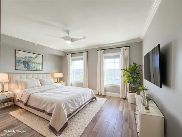 Bedroom featuring hardwood / wood-style floors, ornamental molding, and ceiling fan