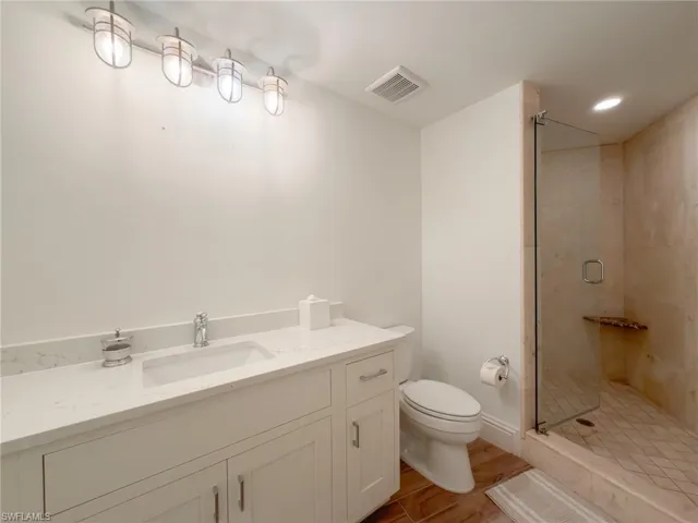 Bathroom with vanity, a shower stall, recessed lighting, and light wood finished floors
