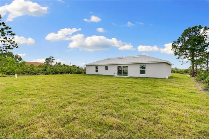 Rear view of property with a lawn