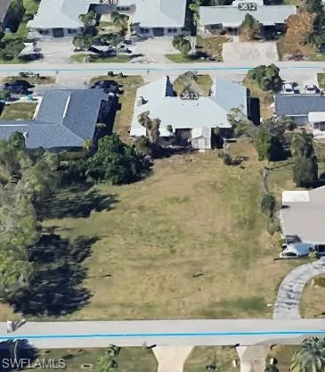 Aerial view of property and surrounding area featuring nearby suburban area