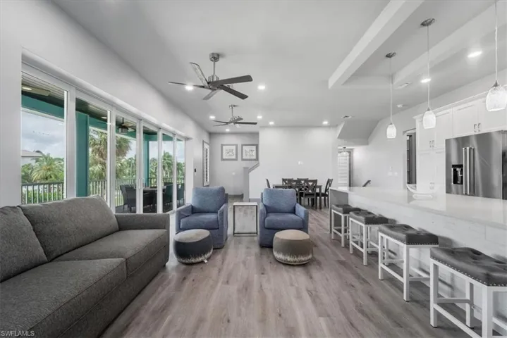 Living room with ceiling fan and light hardwood / wood-style floors