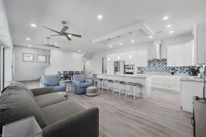 Living room with sink, ceiling fan, and light hardwood / wood-style floors
