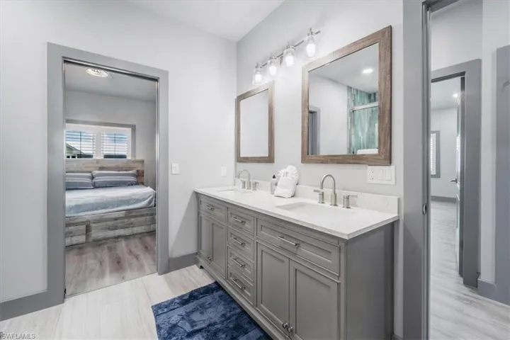 Bathroom with double vanity and hardwood / wood-style flooring
