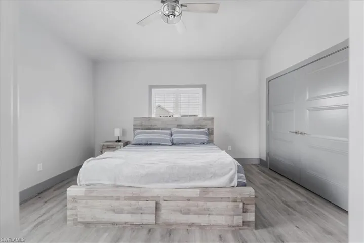 Bedroom featuring ceiling fan, light hardwood / wood-style flooring, and a closet
