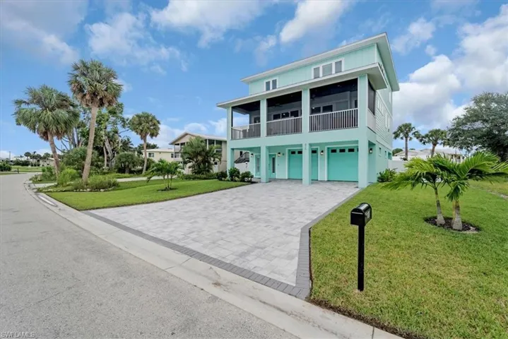 Coastal inspired home featuring a front lawn and a garage