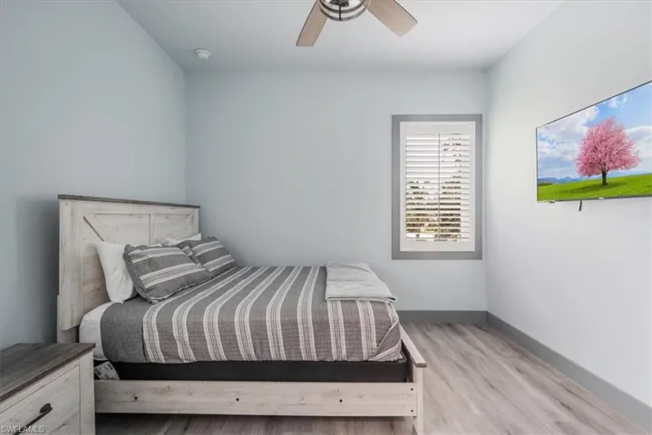 Bedroom with ceiling fan and light hardwood / wood-style flooring