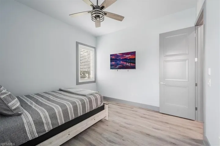 Bedroom with ceiling fan and hardwood / wood-style floors