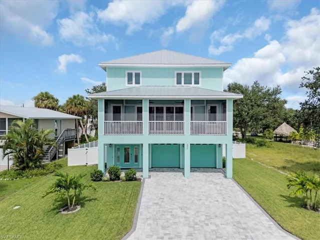 Coastal inspired home with a front lawn and a garage