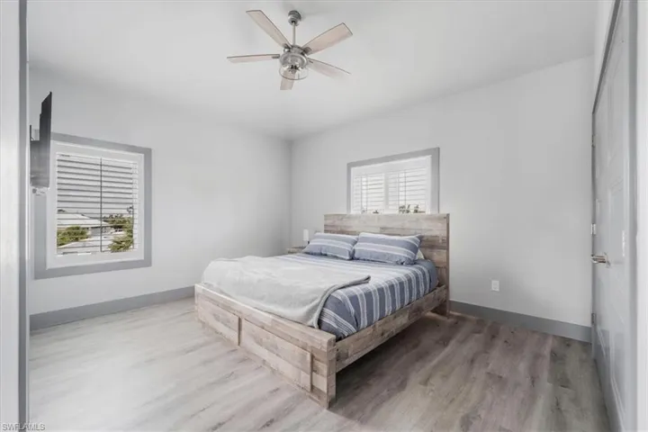 Bedroom featuring ceiling fan, light wood-type flooring, and multiple windows