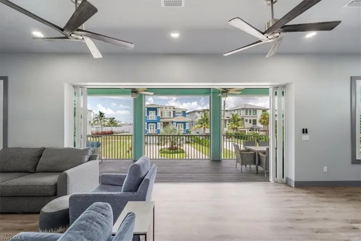 Living room with ceiling fan and hardwood / wood-style flooring