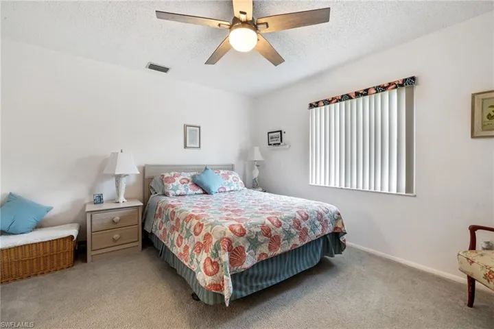 Carpeted bedroom featuring a textured ceiling and ceiling fan