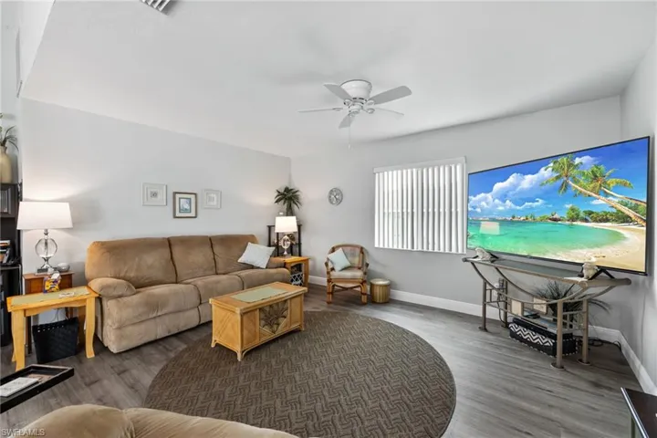 Living room with dark hardwood / wood-style floors and ceiling fan