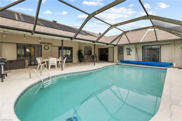 View of swimming pool with a lanai and a patio