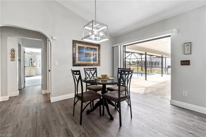 Dining area with vaulted ceiling and hardwood / wood-style flooring