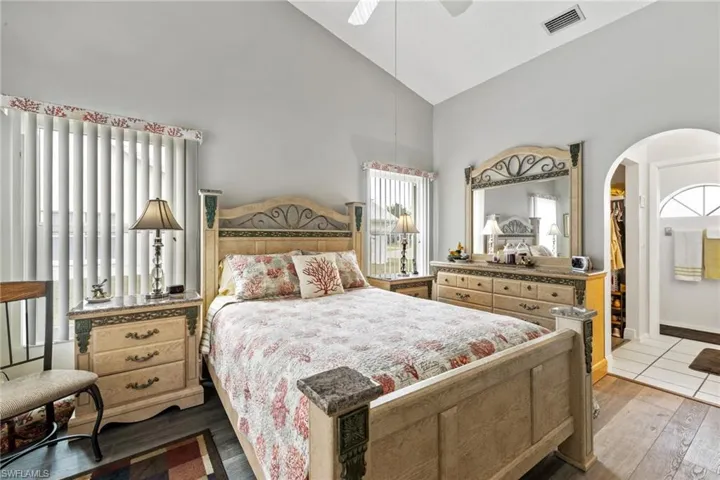 Bedroom featuring ceiling fan, high vaulted ceiling, and wood-type flooring