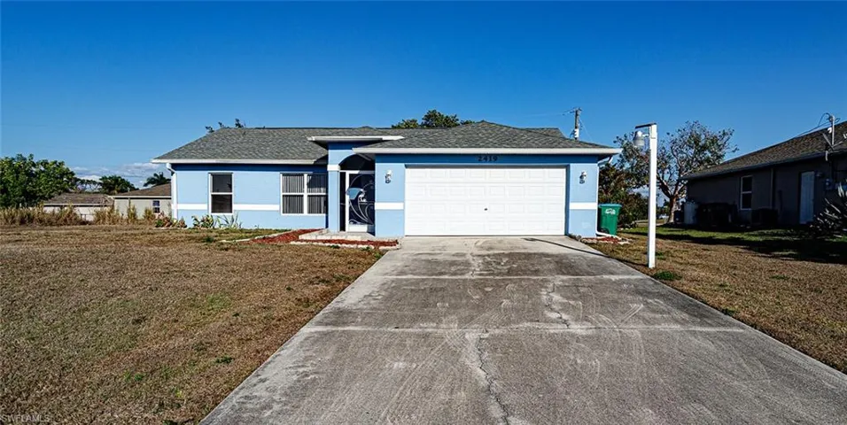 Ranch-style home with stucco siding, a front lawn, driveway, an attached garage, and roof with shingles
