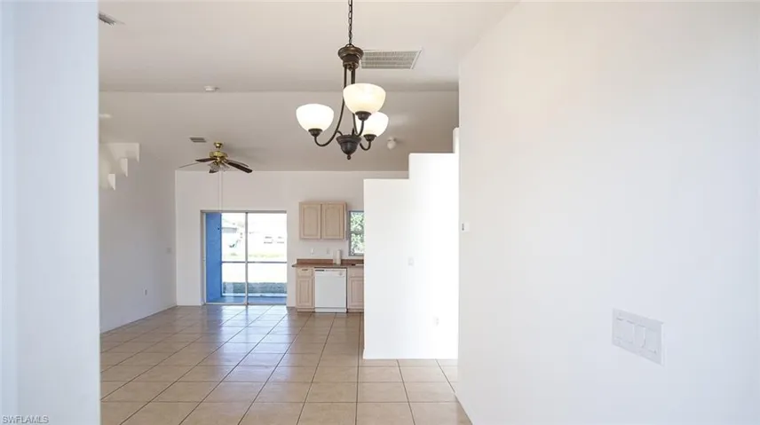 Entry room with light tile patterned floors, hanging lights, and ceiling fan