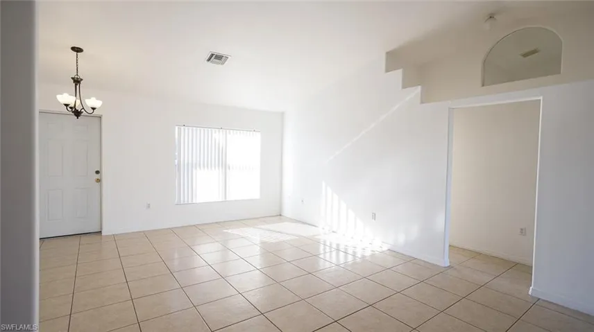 Spare room with hanging lights and light tile patterned flooring