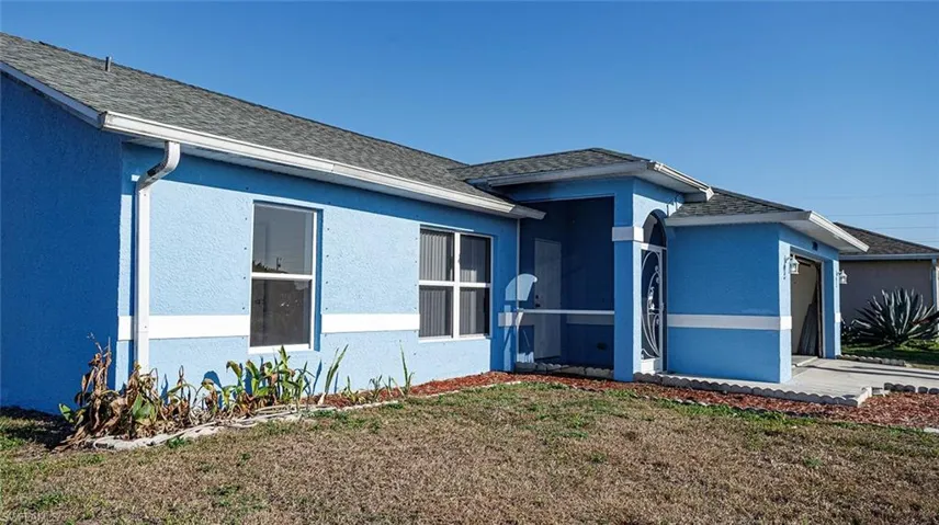 View of front facade featuring roof with shingles, stucco siding, a garage, a front yard, and a sunroom