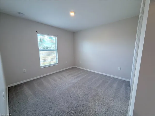Unfurnished room featuring light colored carpet and baseboards