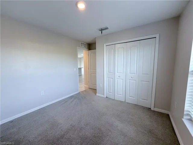 Unfurnished bedroom featuring carpet floors and a closet