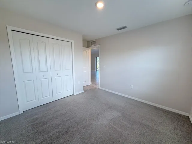 Unfurnished bedroom featuring carpet and a closet