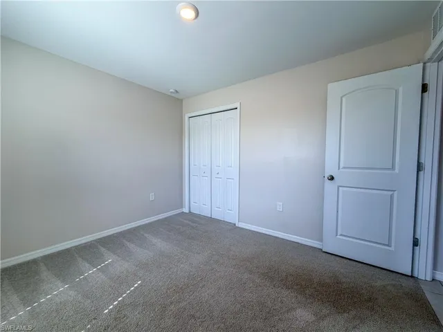 Unfurnished bedroom featuring carpet floors and a closet