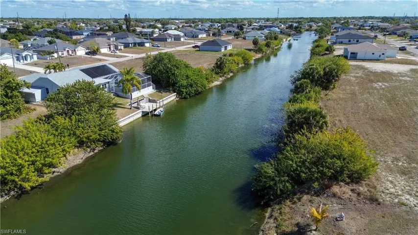 Aerial view of residential area featuring a nearby body of water