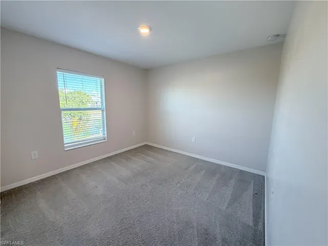 Carpeted empty room with baseboards