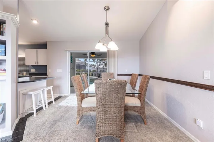 Dining area with baseboards and light carpet