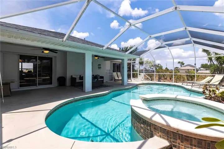 View of swimming pool featuring a sunroom, a patio, a pool with connected hot tub, a lanai, and outdoor lounge area