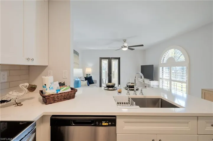 Kitchen featuring white cabinetry, dishwasher, plenty of natural light, and sink