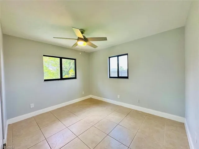 Unfurnished room featuring light tile patterned floors and ceiling fan