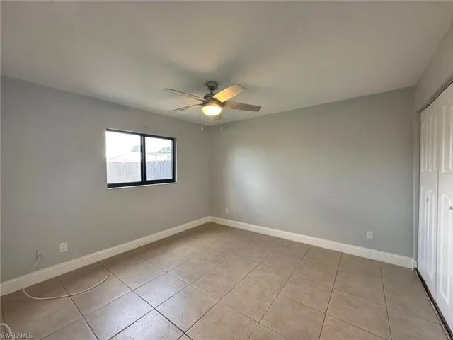 Unfurnished bedroom featuring a closet, ceiling fan, and light tile patterned floors