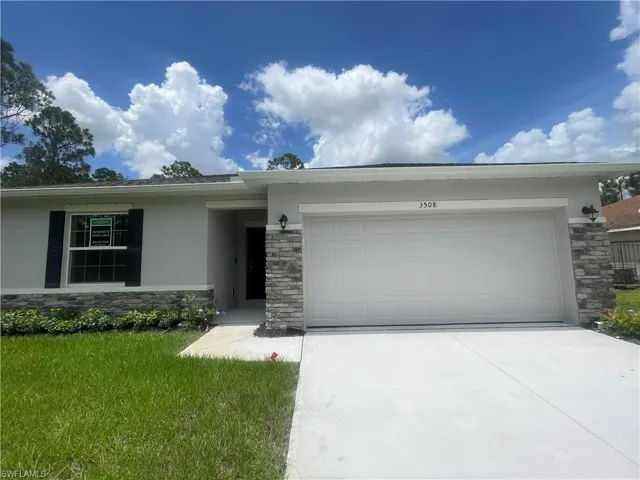 Single story home featuring a garage and a front yard