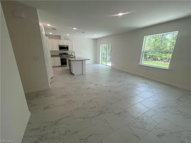 Unfurnished living room featuring sink and light tile patterned floors