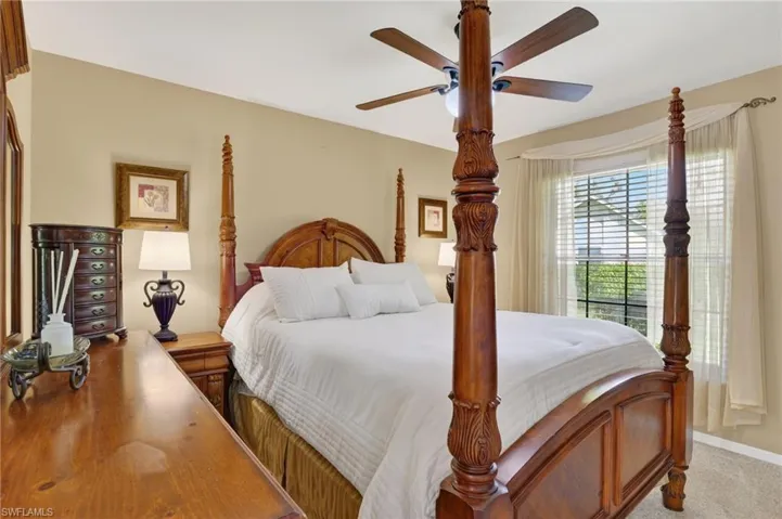 Carpeted bedroom featuring ceiling fan