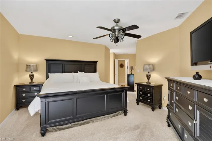 Bedroom featuring light colored carpet, a ceiling fan, and recessed lighting