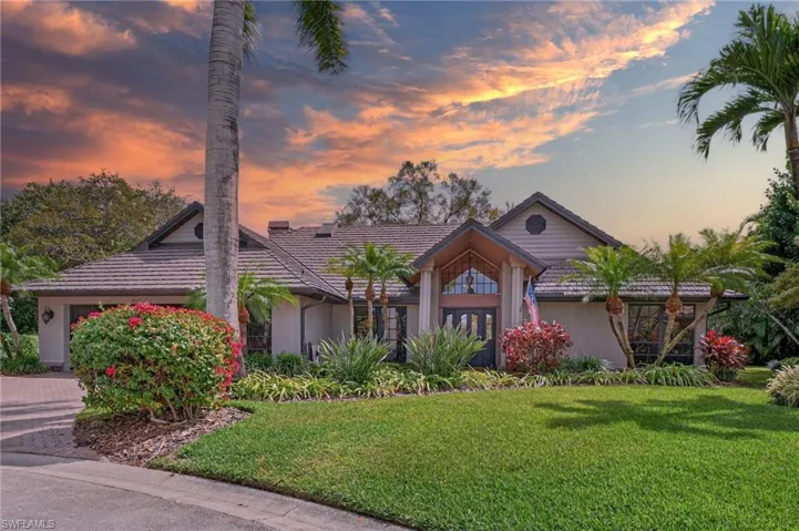 View of front of property featuring a front yard, an attached garage, and driveway