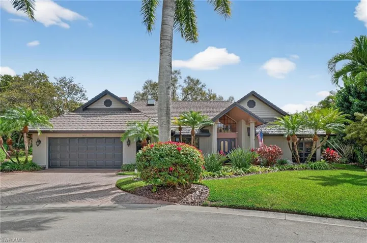 View of front of home featuring decorative driveway, a front lawn, a garage, and a tiled roof