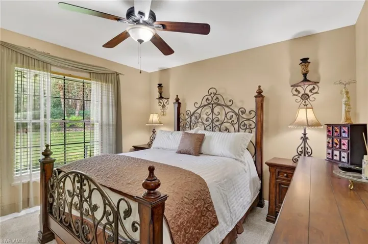 Carpeted bedroom featuring ceiling fan