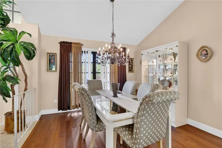 Dining area featuring a chandelier, lofted ceiling, and hardwood / wood-style floors