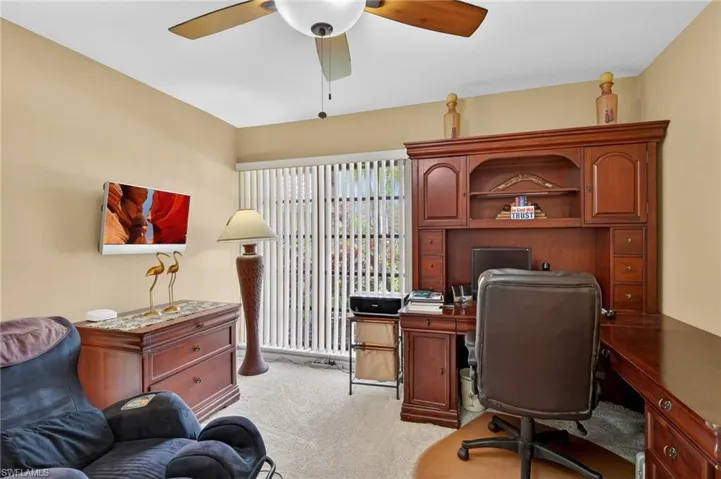 Office space with light carpet and ceiling fan