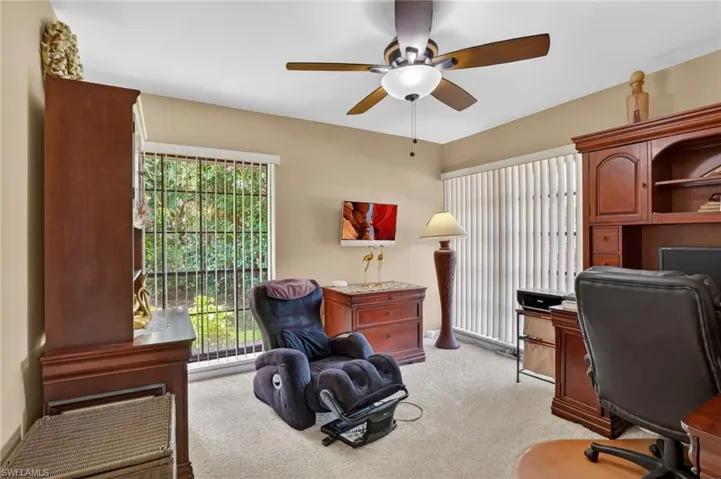 Office space with light carpet and a ceiling fan