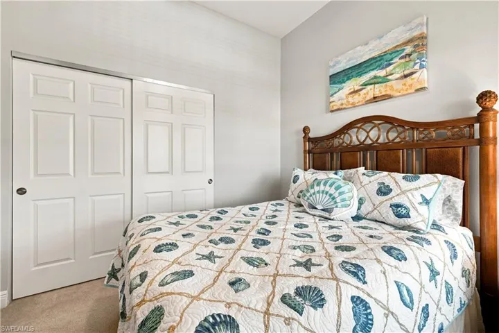 Sliding paneled closet doors, neutral wall paint, and carpeted flooring