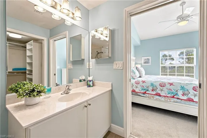 Bathroom vanity with an integrated sink, polished chrome faucet, and expansive mirror